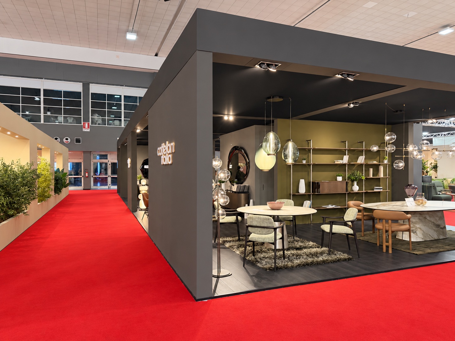 Zona Cattelan Italia con tavoli, sedute e librerie nello stand Avellino Elisa