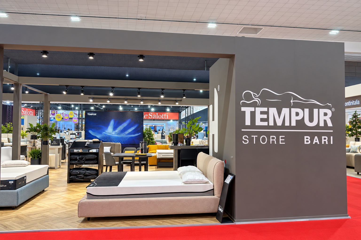 Interno dello stand Tempur con letti, materassi e parete del marchio